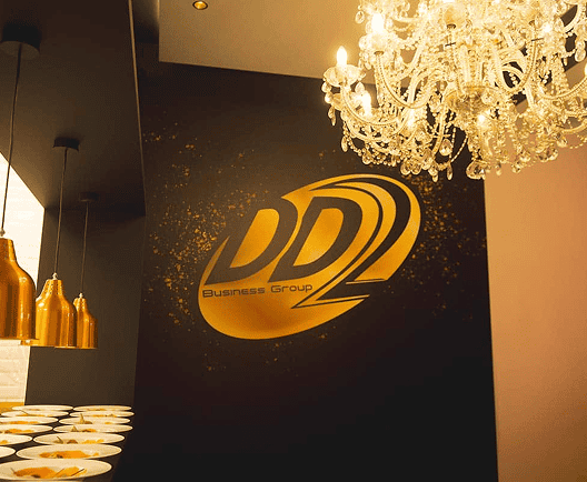 DD2 Business Group logo op de muur met kristallen luchter in de achtergrond